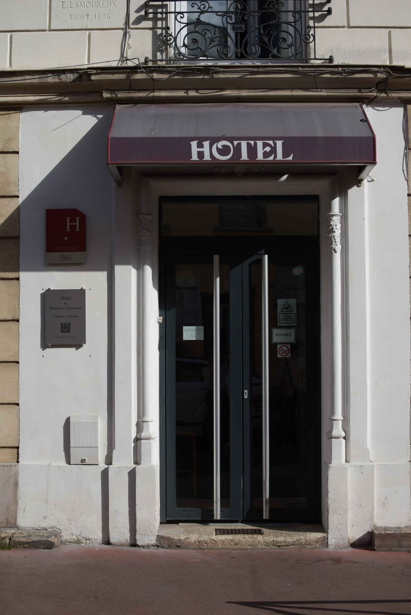 Entrance to Hôtel Résidence Champerret under its burgundy awning